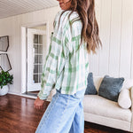 Light apple green and white plaid and gingham print long sleeved top with 1/4 wooden button down front and pleat at placket.