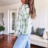Light apple green and white plaid and gingham print long sleeved top with 1/4 wooden button down front and pleat at placket.