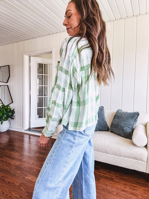 Light apple green and white plaid and gingham print long sleeved top with 1/4 wooden button down front and pleat at placket.
