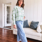 Light apple green and white plaid and gingham print long sleeved top with 1/4 wooden button down front and pleat at placket.