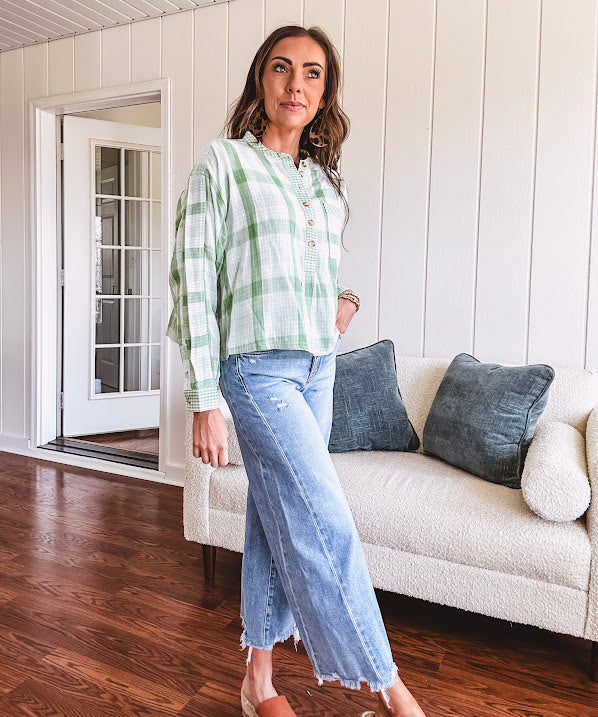 Light apple green and white plaid and gingham print long sleeved top with 1/4 wooden button down front and pleat at placket.
