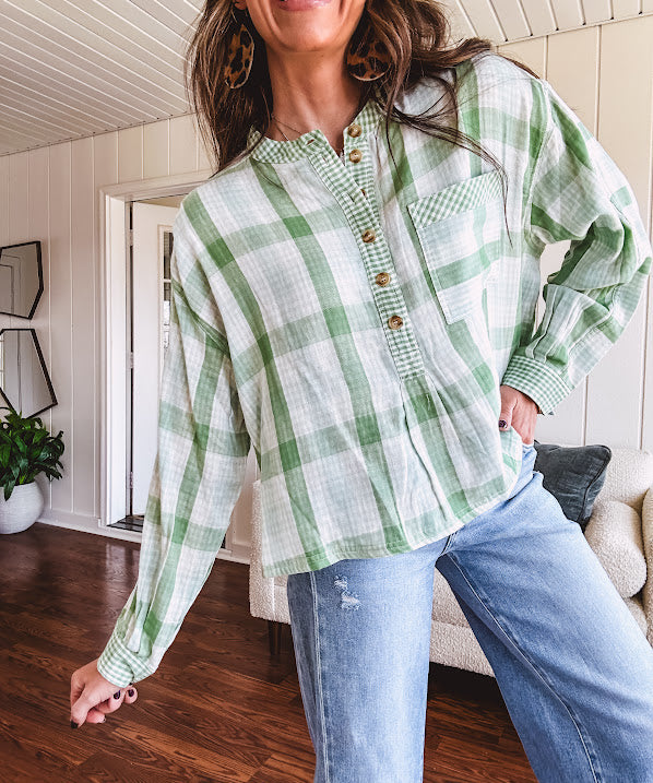 Light apple green and white plaid and gingham print long sleeved top with 1/4 wooden button down front and pleat at placket.