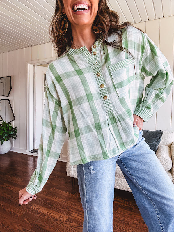 Light apple green and white plaid and gingham print long sleeved top with 1/4 wooden button down front and pleat at placket.