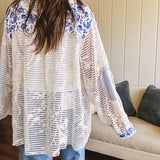 White window pane crochet long sleeved button up with indigo floral details at the yoke, pockets and placket and embroidered crochet throughout.