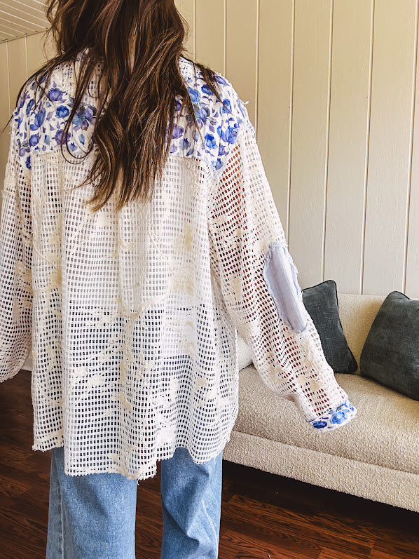White window pane crochet long sleeved button up with indigo floral details at the yoke, pockets and placket and embroidered crochet throughout.