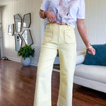 Stretchy lemon colored cropped wide leg pants with scallop trimmed front pockets and button and zipper closure