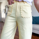 Stretchy lemon colored cropped wide leg pants with scallop trimmed front pockets and button and zipper closure