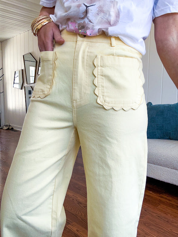Stretchy lemon colored cropped wide leg pants with scallop trimmed front pockets and button and zipper closure
