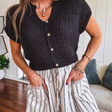 Textured black woven sweater tank with faux wooden buttons down the front and a V neck and hem.