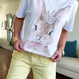 Soft cotton cream colored tee featuring a large brown rabbit with pink accents and rhinestones on the crown and bow.