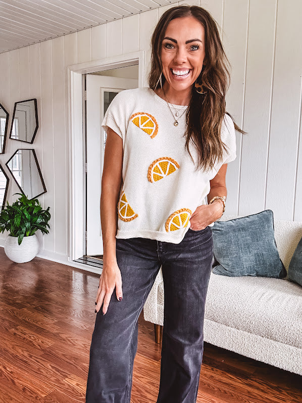 Lightweight cream woven sweater with short, capped sleeves and knitted lemon appliques on the front.