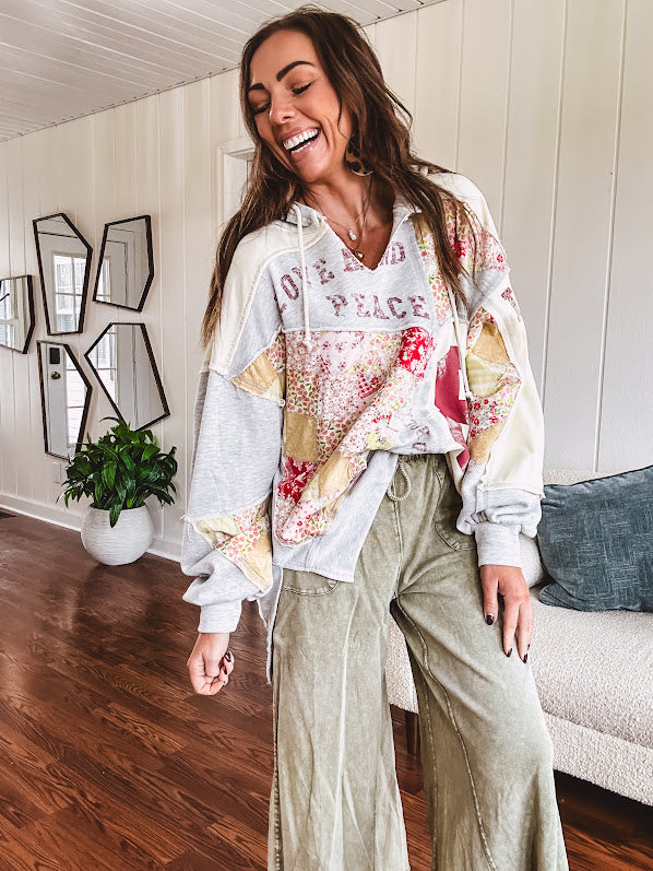 Light grey and cream hoodie with V neck, pink and yellow floral patchwork and retro graphics, split high/low hem.