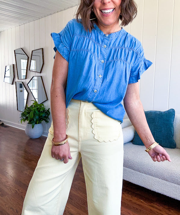 Lightweight medium blue chambray button down top with shirred yoke and ruffled short sleeves.