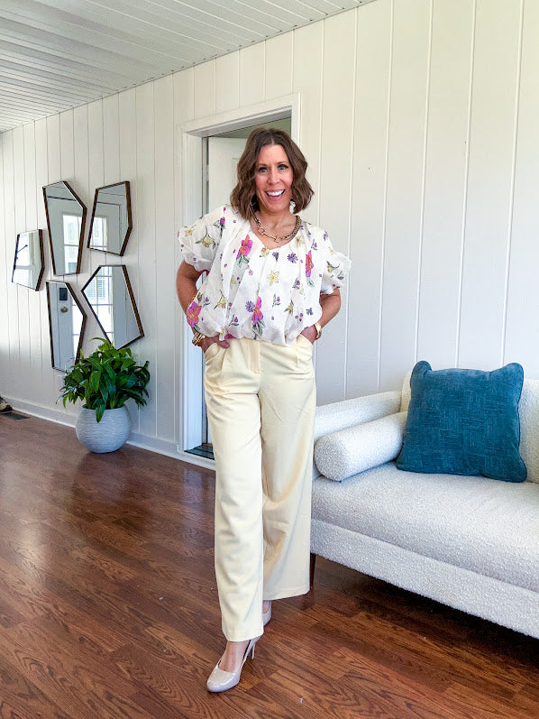 Cream bubble hem blouse with bubble sleeves, pink and yellow florals throughout, V neck and sheer outer layer.