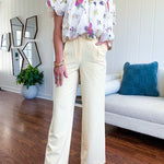 Soft yellow wide leg trousers featuring pintuck pleating on the front, button and zipper closure and elastic at the back.
