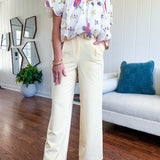 Soft yellow wide leg trousers featuring pintuck pleating on the front, button and zipper closure and elastic at the back.