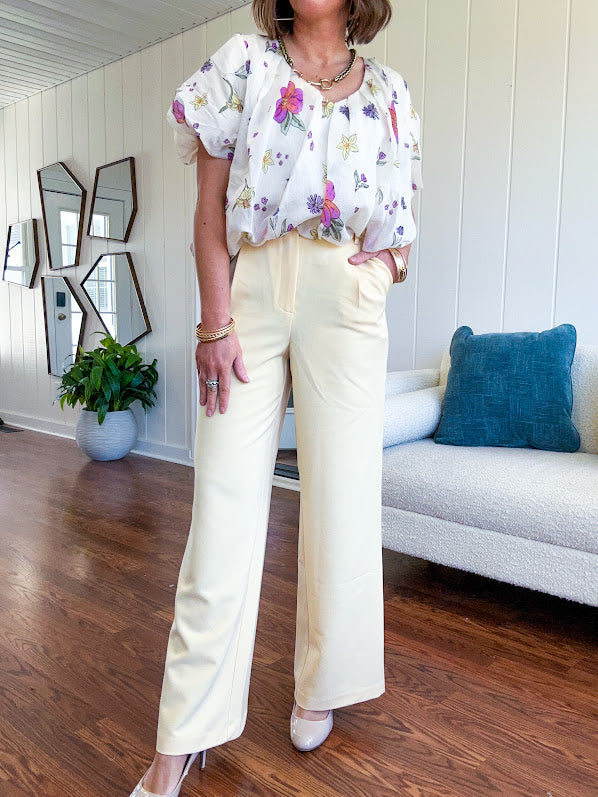 Soft yellow wide leg trousers featuring pintuck pleating on the front, button and zipper closure and elastic at the back.