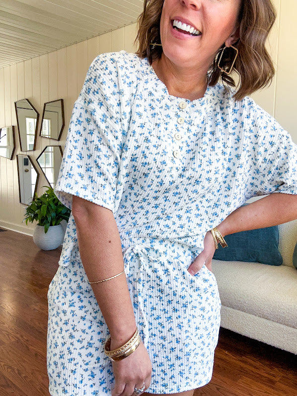 White ribbed Henley style top with small blue florals throughout and matching drawstring, elastic waist shorts with pockets.