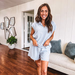Light blue ribbed cap sleeve 1/4 zip top with matching elastic drawstring waist shorts with scalloped trim at the hem and sleeves, trimmed in white.