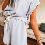 Light blue ribbed cap sleeve 1/4 zip top with matching elastic drawstring waist shorts with scalloped trim at the hem and sleeves, trimmed in white.