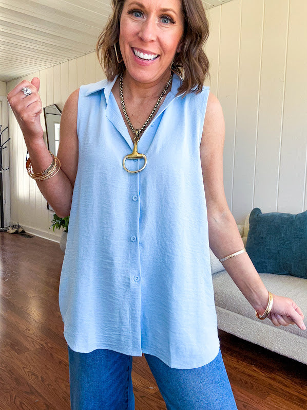 Oversized, flowy button down sleeveless top with collar in light blue.