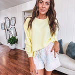 Long sleeved butter yellow ribbed texture pullover with exposed seams throughout and relaxed fit.