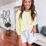 Long sleeved butter yellow ribbed texture pullover with exposed seams throughout and relaxed fit.