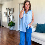 Oversized, flowy button down sleeveless top with collar in light blue.