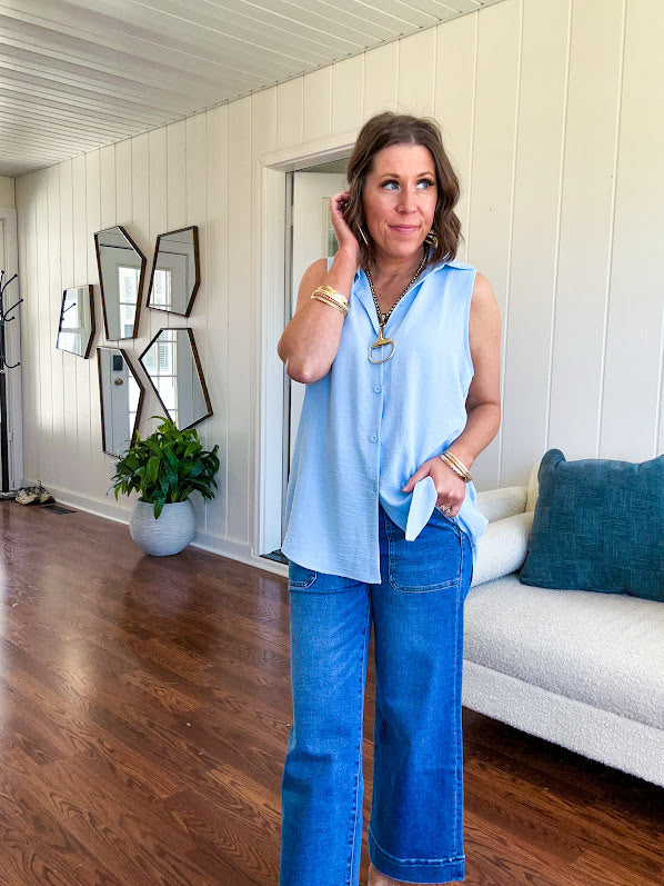 Oversized, flowy button down sleeveless top with collar in light blue.