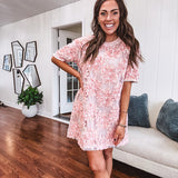 Dusty pink short dress with round neck, short sleeves, tulle overlay with fabric florals with sequined centers and lace accents with pearl trim on the sleeves.