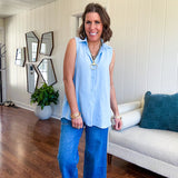 Oversized, flowy button down sleeveless top with collar in light blue.