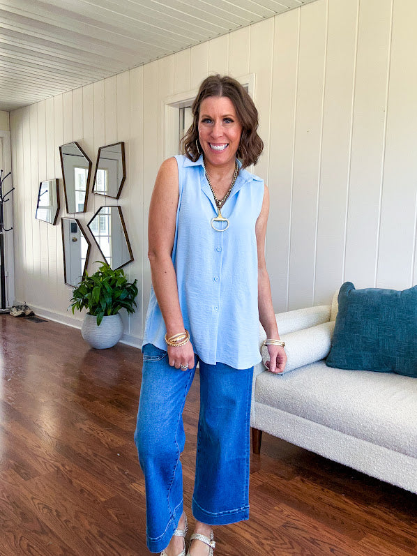 Oversized, flowy button down sleeveless top with collar in light blue.