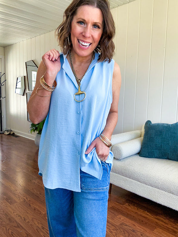 Oversized, flowy button down sleeveless top with collar in light blue.