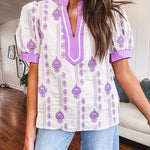 Fully lined lavender and cream blouse with lavender trim at the mock collar and V neck and cuffs, short puffed sleeves and lavender and cream embroidery throughout in an abstract pattern.