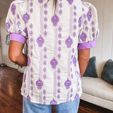 Fully lined lavender and cream blouse with lavender trim at the mock collar and V neck and cuffs, short puffed sleeves and lavender and cream embroidery throughout in an abstract pattern.