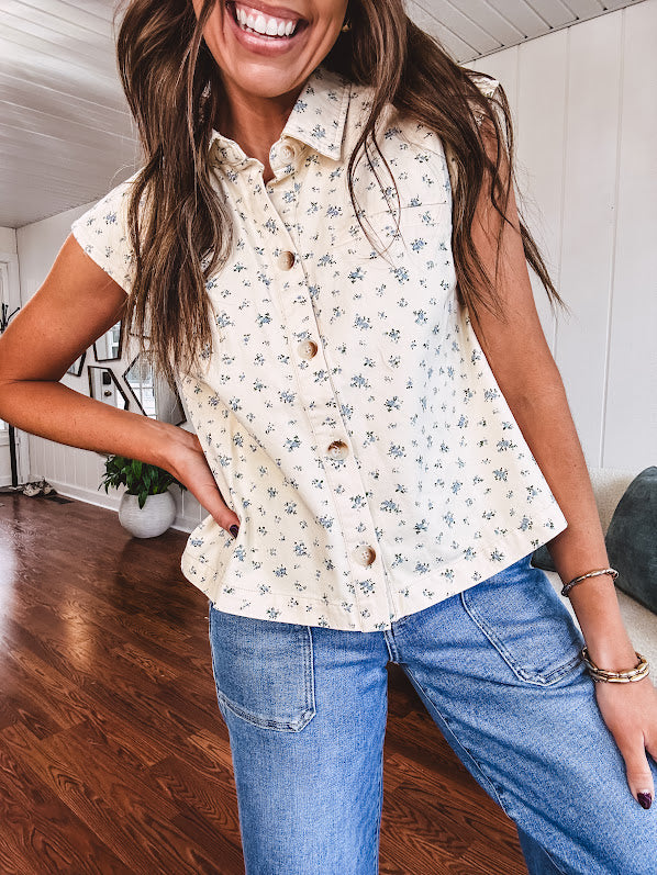 Cream vest with collar and button down front with tiny blue florals throughout.