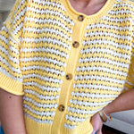 Short sleeved yellow and cream textured weave button down sweater.