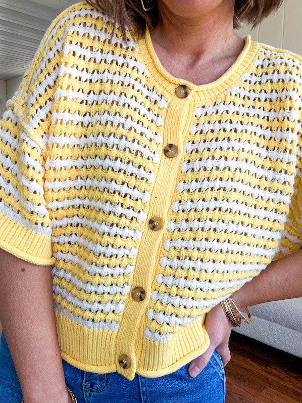 Short sleeved yellow and cream textured weave button down sweater.