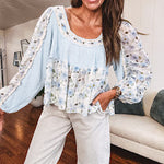 Light blue ribbed texture long sleeved top with sheer blue and green floral inserts at sleeves and ruffled hem with lace embroidery, elastic cuffs and round neck with lace and embroidery trim.
