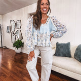 Light blue ribbed texture long sleeved top with sheer blue and green floral inserts at sleeves and ruffled hem with lace embroidery, elastic cuffs and round neck with lace and embroidery trim.