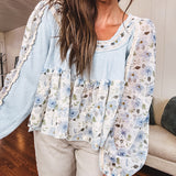 Light blue ribbed texture long sleeved top with sheer blue and green floral inserts at sleeves and ruffled hem with lace embroidery, elastic cuffs and round neck with lace and embroidery trim.