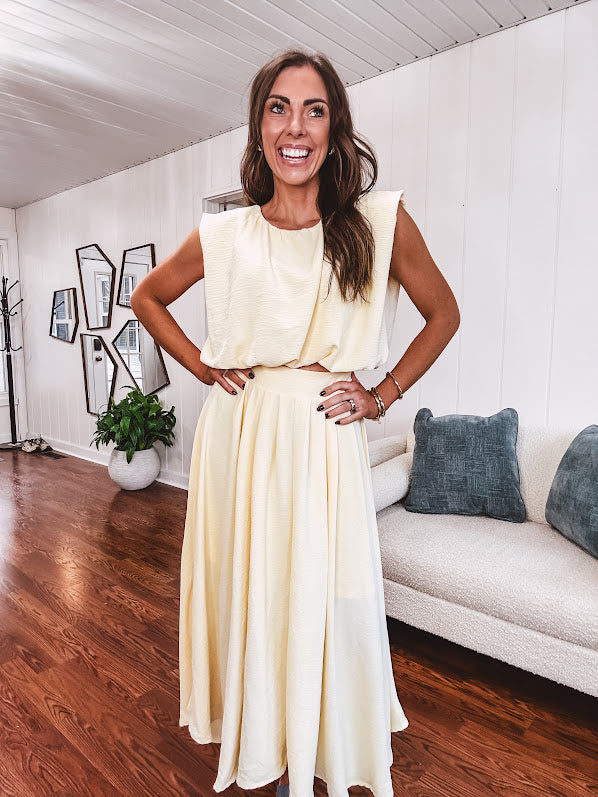 Soft, butter yellow sleeveless top with bubble hem, hook and eye closure at the neck with matching fully lined skirt with flat front waist and pleating with elastic back at the waist, flowy skirt.