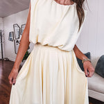 Soft, butter yellow sleeveless top with bubble hem, hook and eye closure at the neck with matching fully lined skirt with flat front waist and pleating with elastic back at the waist, flowy skirt.