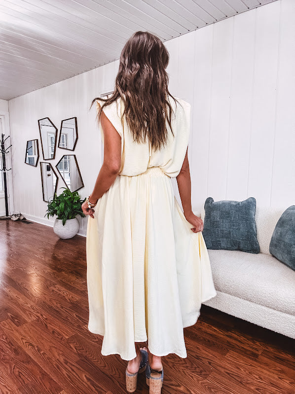 Soft, butter yellow sleeveless top with bubble hem, hook and eye closure at the neck with matching fully lined skirt with flat front waist and pleating with elastic back at the waist, flowy skirt.