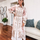 Tan slip dress with long sleeved organza overlay featuring muted florals in pink and cream with vintage inspired design, pearl and gold buttons down the front, cuffs and matching fabric belt with gold accent.