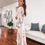 Tan slip dress with long sleeved organza overlay featuring muted florals in pink and cream with vintage inspired design, pearl and gold buttons down the front, cuffs and matching fabric belt with gold accent.