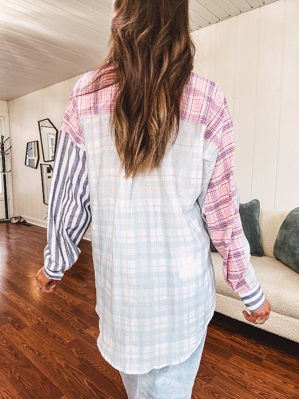 Lightweight, oversized long sleeved button down with pink plaid, light blue plaid and dark blue and white stripes mixed throughout.