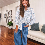 Long sleeved white button down with window pane pattern and blue watercolor florals throughout.