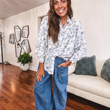 Long sleeved white button down with window pane pattern and blue watercolor florals throughout.