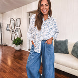 Long sleeved white button down with window pane pattern and blue watercolor florals throughout.